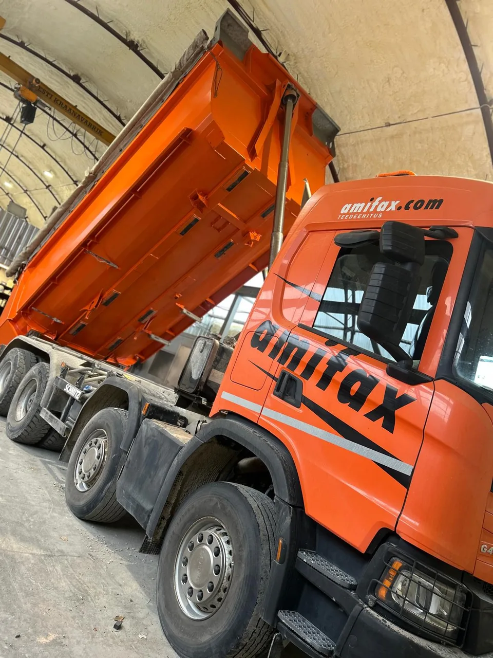 Oranži viimistlusega veoauto ja selle ülestõstetud kast töökojas.