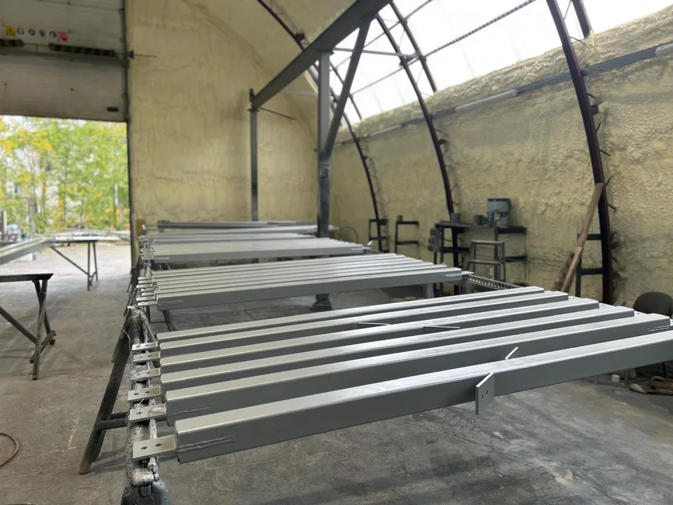 Heleda viimistlusega metallprofiilid ja raamide detailid töökojas.